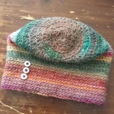 a knitted hat sitting on top of a wooden table