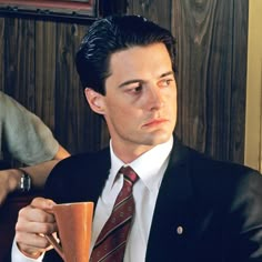 a man in a suit and tie sitting at a table