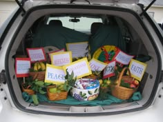 the back end of a car filled with fruit and vegtables for sale