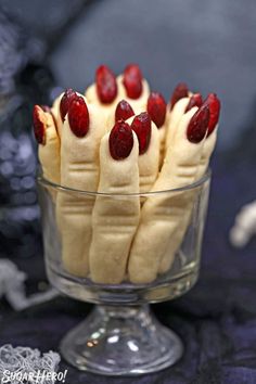 a glass bowl filled with bananas and raspberries on top of a black table