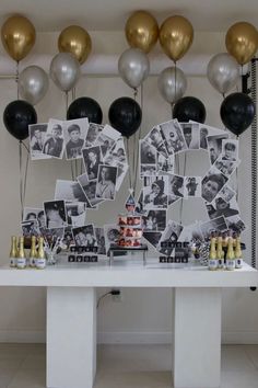 a table topped with balloons and pictures next to a cake on top of a table