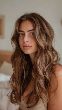 Young woman with long, wavy brown hair gazing softly at the camera indoors. Gold Brunette, Rose Gold Highlights, Dimensional Brunette, Partial Highlights, Coffee Caramel, Balayage Hairstyles, Brunette Balayage, Caramel Balayage