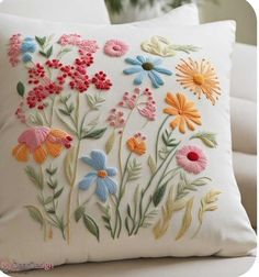 a white pillow with colorful flowers on it