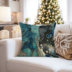 a living room with a christmas tree in the background and pillows on the couches