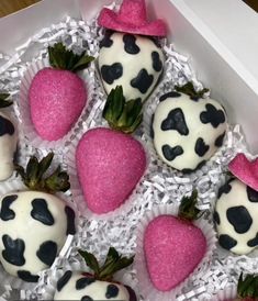 chocolate covered strawberries are in a box with pink and black decorations on them,