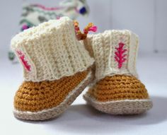 a pair of crocheted baby booties sitting on top of a white table