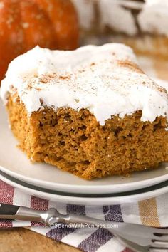 a piece of pumpkin cake on a white plate with a fork and oranges in the background