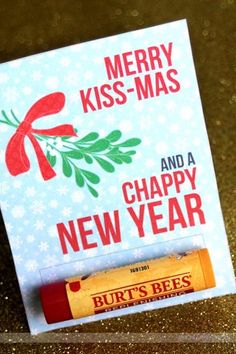 a christmas card with a lip bale and a candy bar on the bottom that says, merry kiss - mas and a happy new year