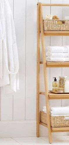 a wooden shelf with towels and soaps on it next to a white towel rack