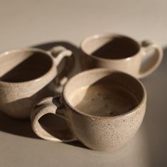 four coffee cups sitting on top of a table