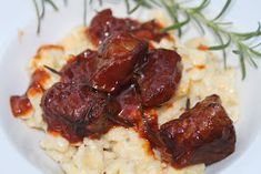 meatballs and rice on a white plate with a sprig of green garnish