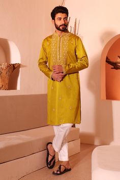 Tan yellow kurta with floral bloom embroidery in beads, sequins, thread work. Paired with a pant.
Components: 2
Pattern: Hand Embroidery
Type Of Work: Floral, Beads, Sequins
Neckline: Stand Collar
Sleeve Type: Full Sleeves
Fabric: Padma Silk
Color: Yellow
Other Details: 
Loop buttons
Occasion: Sangeet - Aza Fashions Eid Kurta With Mirror Work In Chinon, Straight Kurta With Dabka And Kundan, Kundan Kurta With Mirror Work For Eid, Eid Kurta With Mirror Work, Yellow Chinon Kurta With Mirror Work, Eid Dola Silk Kurta With Mirror Work, Chinon Kurta With Gota Work For Eid, Yellow Kurta For Navratri, Eid Chinon Kurta With Gota Work