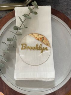 a white napkin with the word brooklyn on it sitting on top of a silver plate