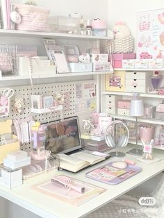 a white desk topped with lots of shelves filled with pink and white items on top of it