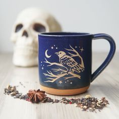 a blue coffee mug with a bird on it next to a dried star anisette