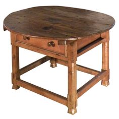 a round wooden table with drawers on each side