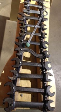 several different types of wrenches sitting on top of a wooden board