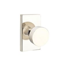 an image of a white door knob on the side of a wall mounted toilet paper dispenser