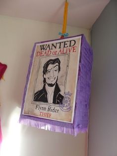 a sign hanging from the ceiling above a bed in a room with white walls and purple fringes