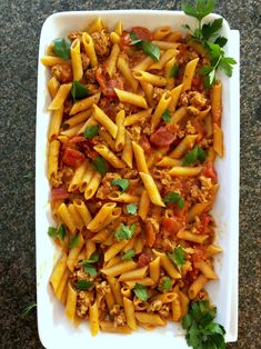 pasta with meat and tomato sauce in a white casserole dish