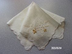 two white napkins with embroidered flowers on them