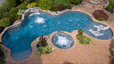 an aerial view of a swimming pool surrounded by landscaping