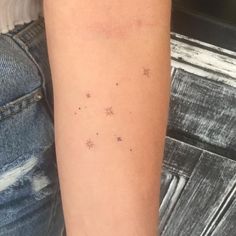 a woman's arm with small stars on the back of her left arm,