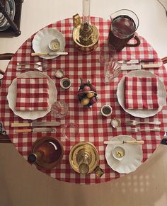 a red and white checkered table cloth with place settings