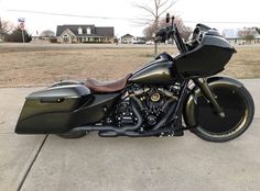 a black and gold motorcycle parked in front of a house