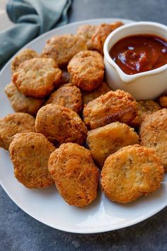 a white plate topped with fried food next to a dipping sauce