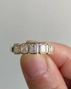 someone is holding an old diamond ring in their left hand and it has five diamonds on each side