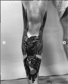 a black and white photo of a man's leg with an eagle tattoo on it