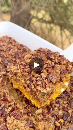 two pieces of granola sitting in a white casserole dish on top of a wooden table