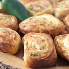 there are many different types of breads on the plate with green peppers in the background