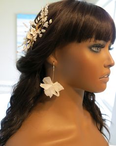 a mannequin head wearing a white flower and leaf hair piece