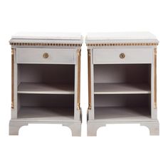 a pair of white nightstands with gold trimming on the top and bottom shelves