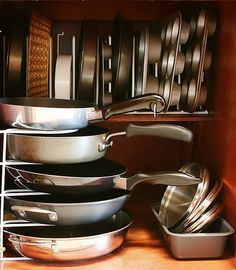 pots and pans are stacked on the shelf