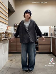 a man standing in the middle of a kitchen with his hands out and looking at the camera