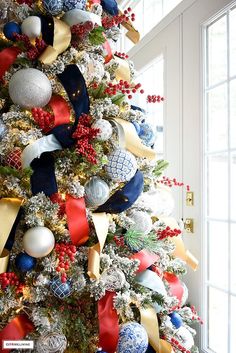 a decorated christmas tree with red, white and blue ornaments