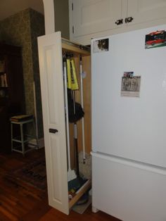 a white refrigerator freezer sitting inside of a kitchen next to a wooden flooring