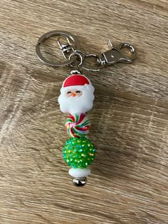 a keychain with a santa clause on it sitting on top of a wooden table