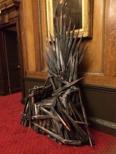 a game of throne sitting on top of a red carpet in front of a painting