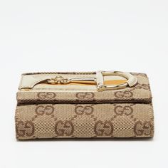 Gucci Beige GG Canvas and Leather Web Horsebit Compact WalletThis Gucci wallet is stacked with signature details. Created from the GG canvas and leather it is adorned with a Horsebit on the front and exhibits gold tone hardware. The compartmentalized interior of this wallet will keep your monetary essentials organized. Size: Height: 9 cm Width: 2.5 cm Length: 11 cmColour: BeigeMaterial: Canvas Leather Compact Wallet, Gold Ounce, Gucci Wallet, Wallet Fashion, Fendi Bags, Canvas Leather, Prada Bag, Dior Bag, Chanel Bag