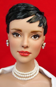 a mannequin head with black hair and pearls on it's neck, wearing a white shirt