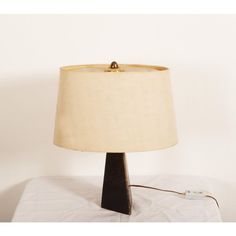 a lamp that is sitting on top of a table with a white cloth underneath it