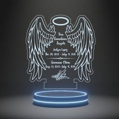 an illuminated memorial plaque with angel wings