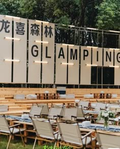 an outdoor dining area with tables and chairs in front of a sign that says glamping