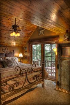 a large bed sitting inside of a bedroom on top of a wooden floor next to a window