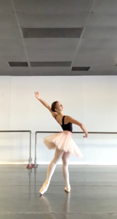 a young ballerina is practicing in an empty room