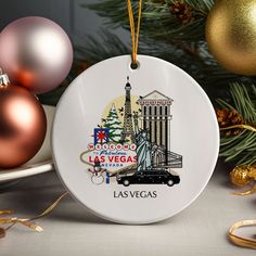 a christmas ornament with the las vegas skyline and statue of liberty on it